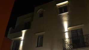 Ένα πολυώροφο κτίριο με φωτισμένα παράθυρα και ένα μπαλκόνι.