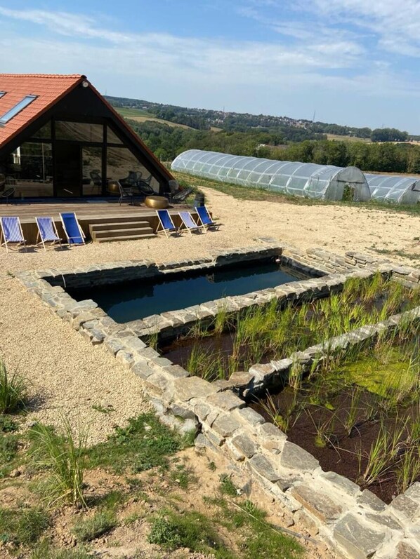 A rustic cabin with a red roof, a swimming pool, and a greenhouse in the background. - LITTLE FARM Prestige House (Ittre)