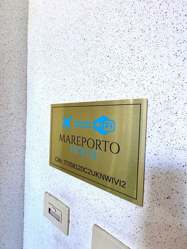 A sign with the text 'MAREPORTO HOUSE' and a Wi-Fi symbol, indicating a hotel room with internet access.