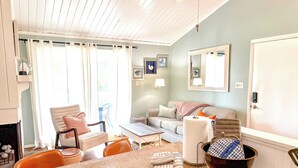 A living room with a fireplace, a dining table, and a sofa. - Family Favorite Beach & Golf Condo with a View (Edisto Island)