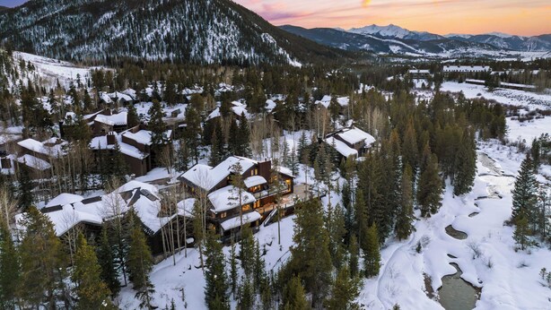 A snow-covered mountain village with multiple cabins and a large lodge with a prominent entrance. - Luxury Mountain Estate w/ Indoor Pool, Gym & Hot Tub Near Keystone | Sleeps 19 (Keystone)