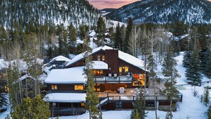 A large, multi-story lodge with a wooden exterior, surrounded by snow-covered trees and mountains. - Luxury Mountain Estate w/ Indoor Pool, Gym & Hot Tub Near Keystone | Sleeps 19 (Keystone)