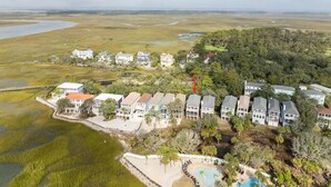 Un quartier résidentiel situé sur la côte, avec des maisons, une piscine et une plage.