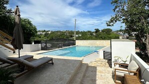 A rooftop pool area with lounge chairs and a view of the surrounding landscape. - Casa Rosado @ Rincon Rayo Suite Mountain View Pool (Cruces)