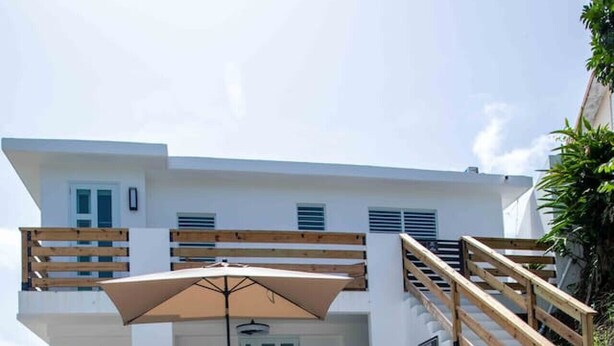 Una casa moderna con piscina, terraza de madera y zona de estar al aire libre.