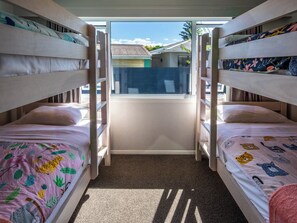 Een slaapkamer met stapelbedden en uitzicht.