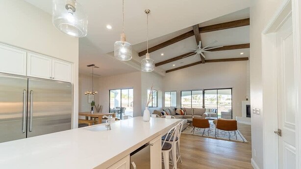 A spacious kitchen with a large island, modern appliances, and a ceiling fan.