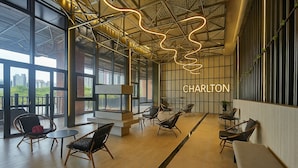Un salon moderne doté d’une cheminée, de sièges confortables et offrant une vue sur le paysage urbain.