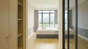 Une chambre d’hôtel moderne avec un grand lit, une armoire et une vue sur la ville.