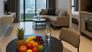 Une chambre d’hôtel moderne dotée d’un coin repas, d’un canapé, d’une télévision et d’une cuisine.