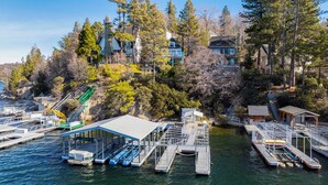A marina with docked boats, a covered boat launch, and houses surrounded by trees. - Stunning Lake Views To Die For On Lake Arrowhead (Lake Arrowhead)