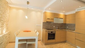 A modern kitchen with a built-in oven, granite countertop, and wooden cabinets. - The Cristal apartment house is situated in a quiet, sunny and central location (Leukerbad)