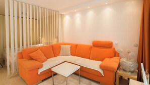 A modern living room with a sectional sofa, a small white coffee table, and a decorative vase on a side table. - The Cristal apartment house is situated in a quiet, sunny and central location (Leukerbad)