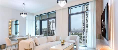 A modern living room with a sofa, coffee table, and dining area.