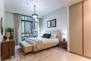 Ein modernes Schlafzimmer mit einem großen Bett, Nachttischen, einer Stehlampe und Blick auf hohe Gebäude.