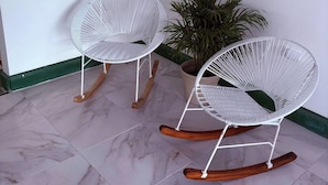 Two white rocking chairs with wooden legs on a tiled floor. - Turbay House 1 (Cartagena de Indias)