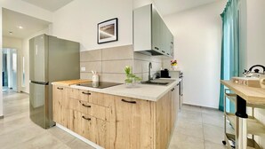 A modern kitchen with a central island, stainless steel refrigerator, and wooden cabinetry. - Sea Life Giulia, 200 meters from the beach (ALCAMO)