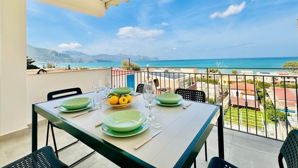 A balcony with a table set for dining, overlooking a coastal view. - Sea Life Giulia, 200 meters from the beach (ALCAMO)
