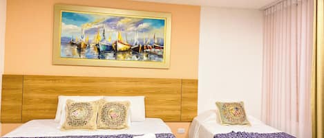 Une chambre d’hôtel avec deux lits, une tête de lit en bois, un tableau représentant des voiliers et une fenêtre avec des rideaux.