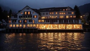 A waterfront hotel with multiple floors and a dock. - Seehotel Schwert (Gersau)