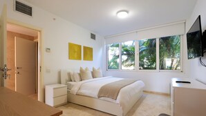Una camera da letto con un letto, comodini, una scrivania e una televisione.