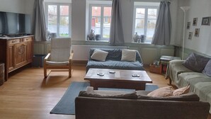 A living room with a sofa, armchair, coffee table, and a television. - La Bretz'elle, country house in the Vosges du Nord Natural Park (Lohr)