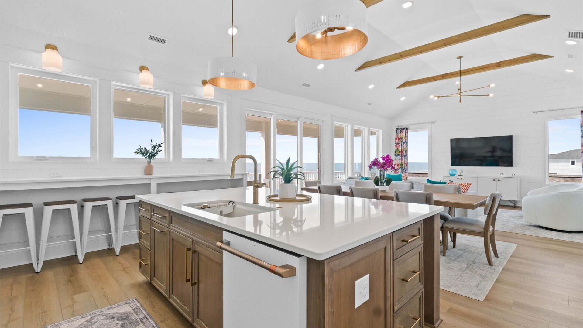 A spacious kitchen with a large island, wooden cabinets, and a modern pendant light.