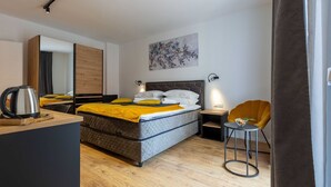 Una habitación de hotel moderna con una cama, un escritorio, una silla y una cafetera.