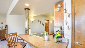 A kitchen with a wooden dining table, chairs, a vase with fruits, and wall-mounted light fixtures. - 7 Mi to Dtwn Denver: Lakefront Gem w/ Dock! (Denver)