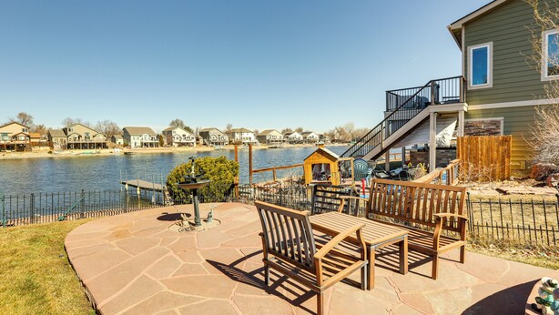 A patio with outdoor furniture overlooking a lake, a wooden deck, and a house with a staircase leading to a deck. - 7 Mi to Dtwn Denver: Lakefront Gem w/ Dock! (Denver)