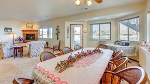 A spacious living room with a fireplace, dining area with a long table, and large windows. - 7 Mi to Dtwn Denver: Lakefront Gem w/ Dock! (Denver)