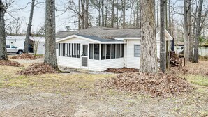 A single-story mobile home with a covered porch, surrounded by trees and a gravel driveway. - 1 Mi to Lake Murray! Pet-Friendly Extended Getaway (Prosperity)