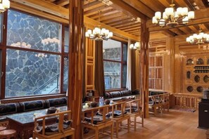 A wooden interior with high ceilings, chandeliers, and large windows.
