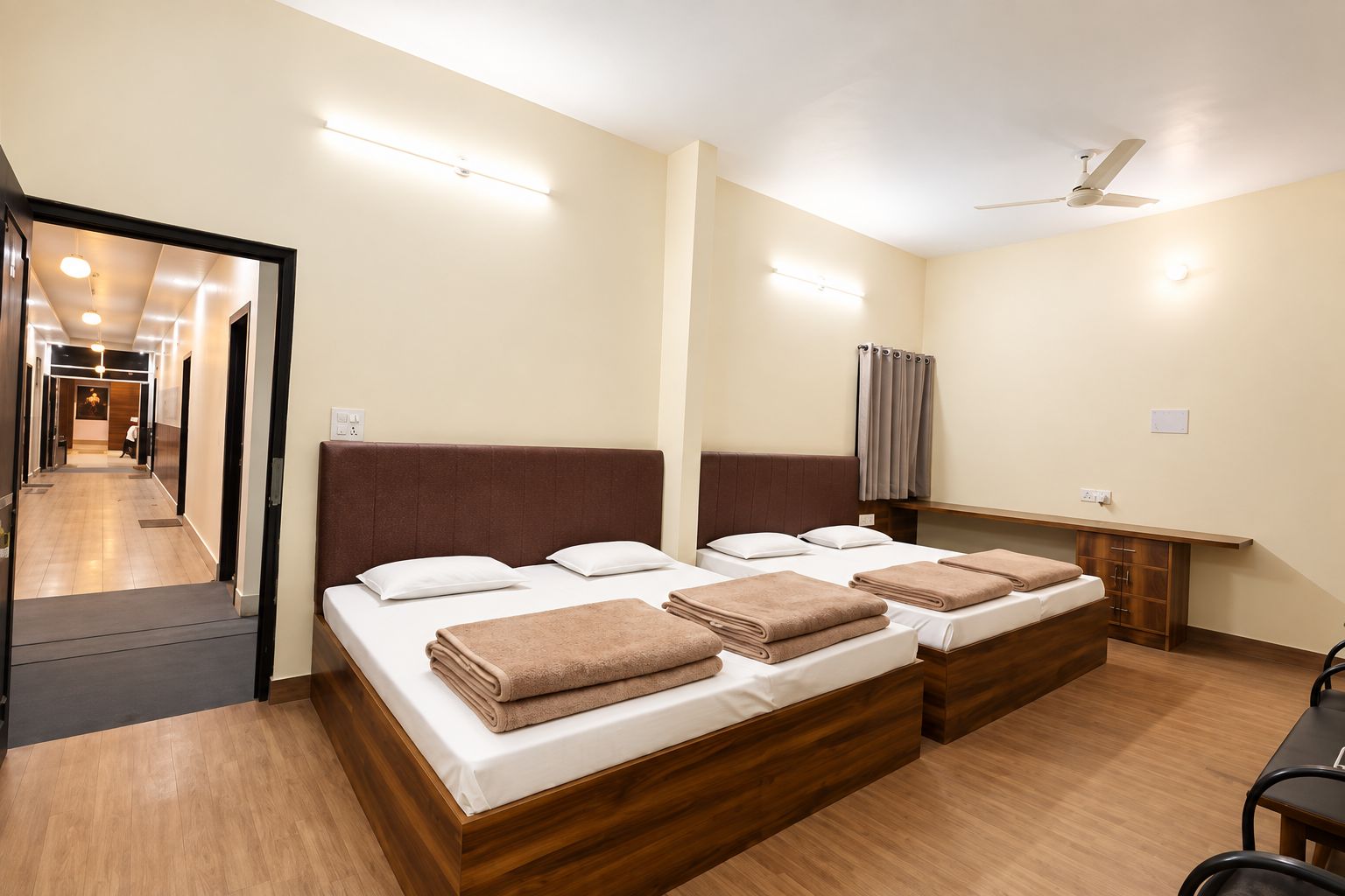 A hotel room with a large bed, a desk, and a ceiling fan.