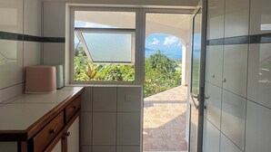 Een moderne keuken met uitzicht op groen en een heldere lucht.