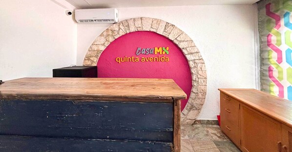 A reception area with a stone arch and a pink wall displaying the text "CASA MX quinta avenida". - Hostal CASA MX quinta avenida (Playa del Carmen)