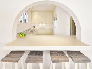 Una cocina moderna con un arco, una isla central y taburetes de bar.