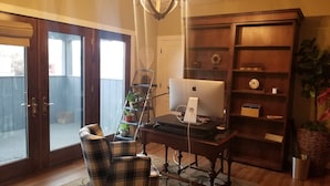 A home office with a desk, chair, computer, bookshelf, and a potted plant. - Charming 1-bedroom apartment with WiFi, AC in downtown Kalispell Main Street (Kalispell)