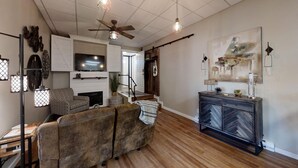 A living room with a fireplace, a TV, and a bar area. - Charming 1-bedroom apartment with WiFi, AC in downtown Kalispell Main Street (Kalispell)
