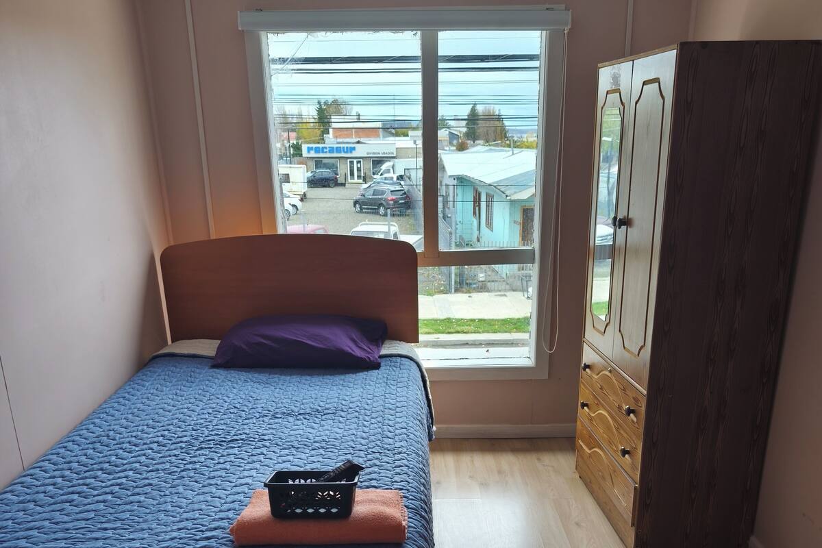Une chambre à coucher avec un lit, une fenêtre et une armoire.