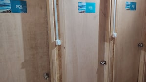 Wooden doors with 'DUCHA SHOWER' signs, indicating shower facilities.