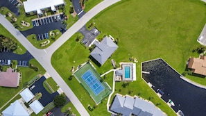 An aerial view of a residential area with a swimming pool, tennis court, and a parking lot. - Gorgeous 2 BR / 2 BA waterfront condo in Punta Gorda - The River's End (Punta Gorda)