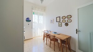 Un coin repas avec une table et des chaises en bois, un lustre et des tableaux encadrés accrochés au mur.