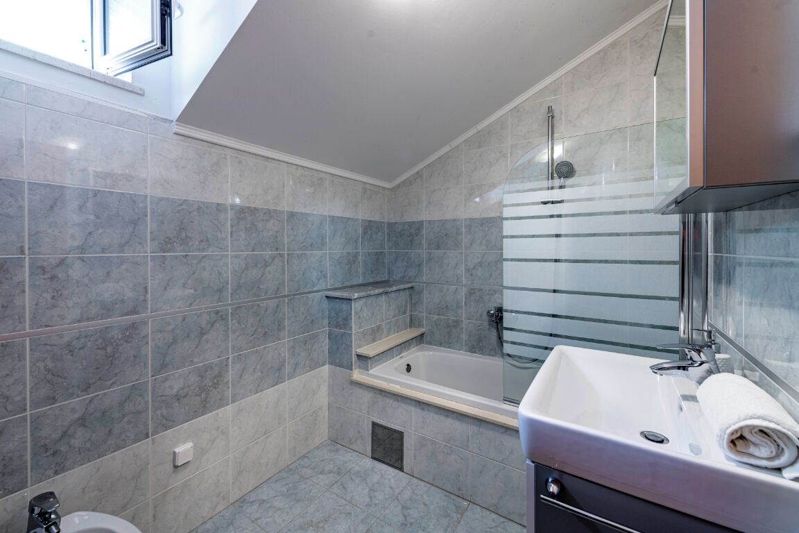 A modern bathroom with a bathtub, a sink, and a shower.