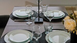 Une table dressée pour deux personnes, avec vue sur un port et des bâtiments historiques.