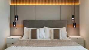 A modern bedroom with a large bed, two bedside tables, and wall-mounted lighting. - Incredible 10bd Summerkitchen Windsor Cay (Clermont)