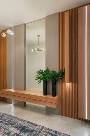 Un interior moderno con un banco empotrado, paneles de madera verticales y una lámpara colgante.