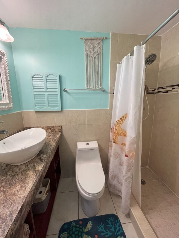 A bathroom with a sink, toilet, and shower. - Island Dream Getaway (Christiansted)
