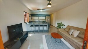 Una cucina moderna con zona pranzo, divano e TV.