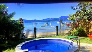 Una piscina con vistas a una playa y barcos en el agua.